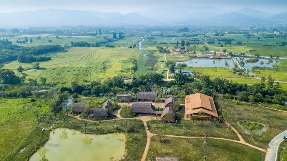 Open green fields, waterways and low buildings across the Liangzhu archaeological landscape
